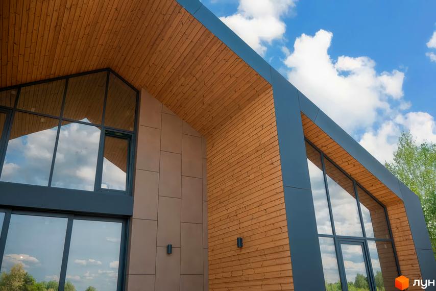 Котеджне містечко Piemont eco village з дерев'яним фасадом та великими вікнами. Зовнішній вигляд будинку з акцентом на натуральні матеріали та природне освітлення.