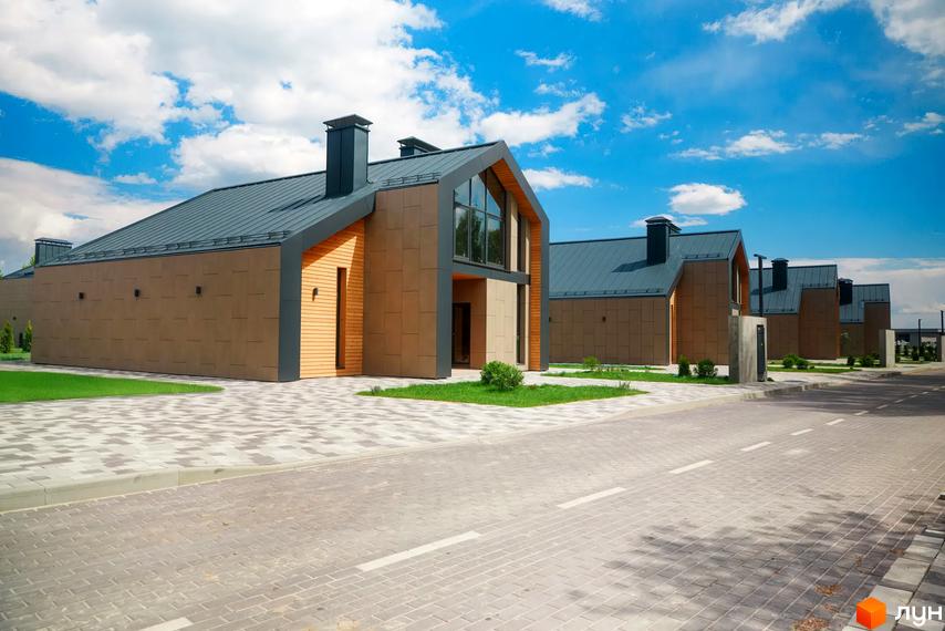 Котеджне містечко Piemont eco village з сучасними будинками та доглянутою прибудинковою територією. Фасади оздоблені натуральними матеріалами, дахи вкриті металочерепицею.