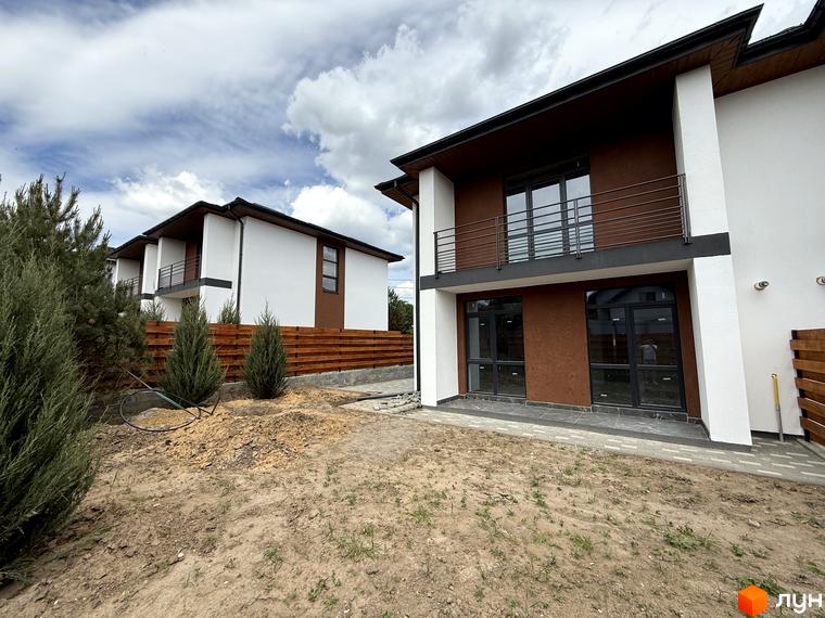 Котеджне містечко VillaTwins: двоповерхові будинки з біло-коричневим фасадом та темними вікнами. Прибудинкова територія з ґрунтом та молодими деревами.