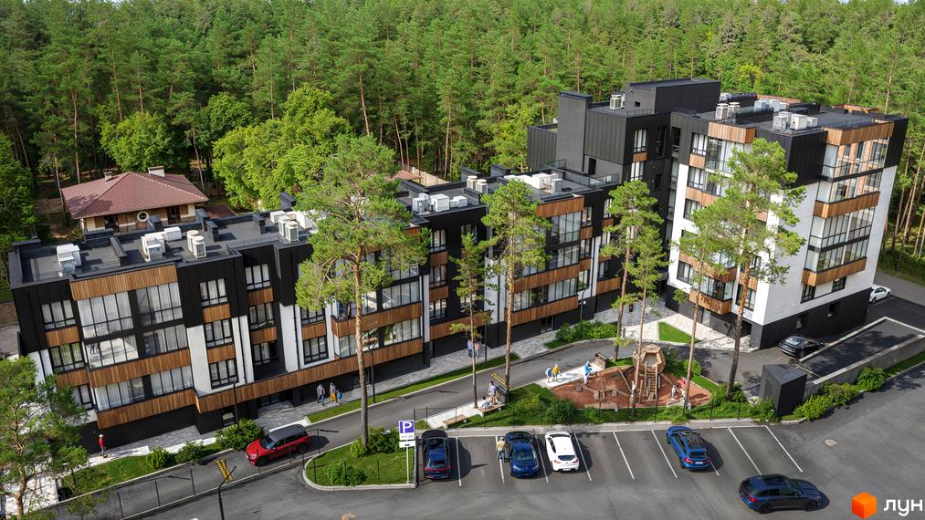 Житловий комплекс Author з чорно-білими фасадами та дерев'яними елементами серед сосен. На території є дитячий майданчик та паркінг.