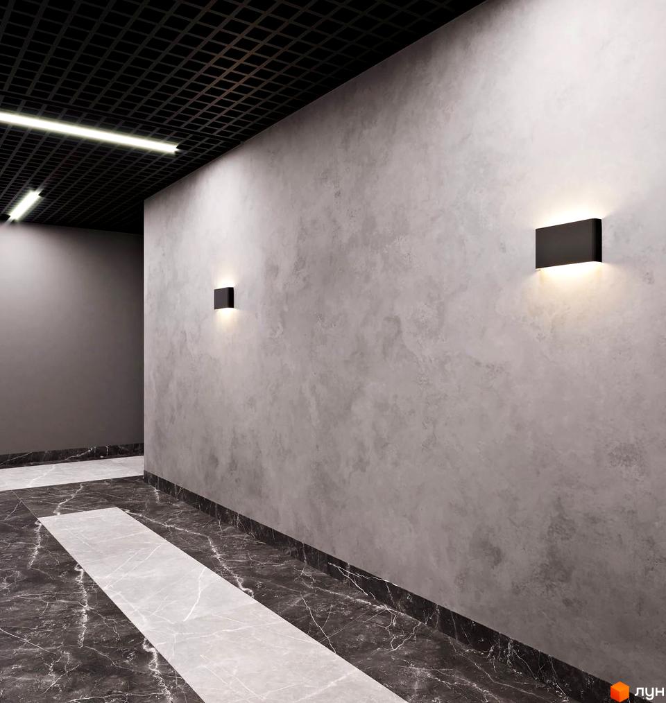 Інтер'єр коридору Апарт-комплексу Breeze Marine з сірими стінами, чорною ґратчастою стелею та мармуровою підлогою.