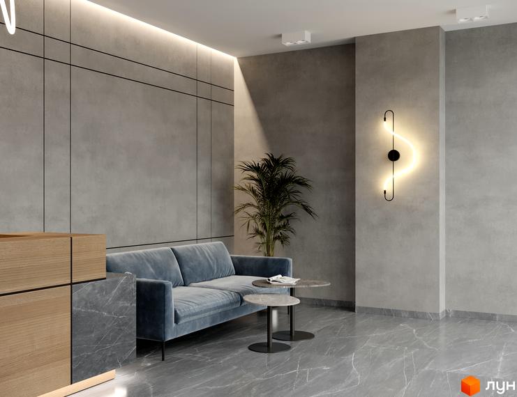 Інтер'єр загальної зони Комплексу Breeze Marine: сірі панельні стіни, блакитний диван, мармурова підлога та декоративне освітлення.