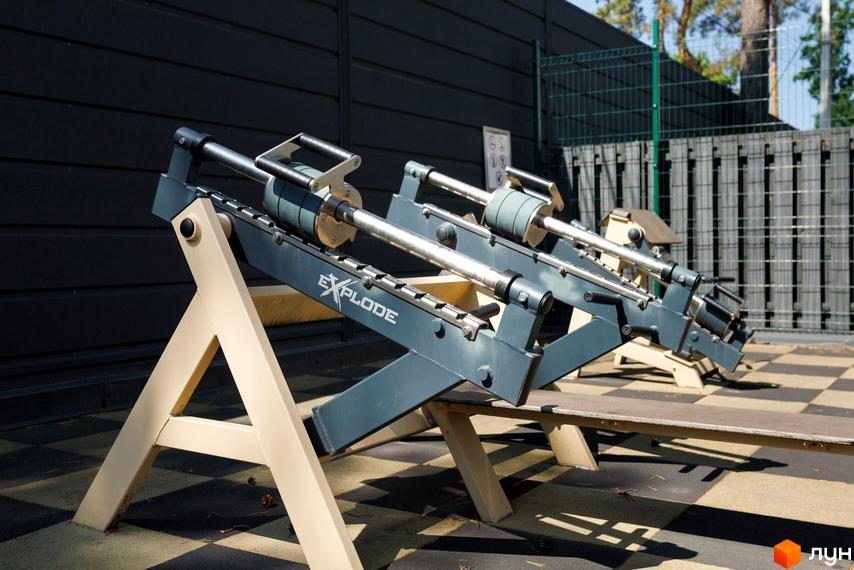 Комплекс КМ Park Residence 3. Атракціон з металевими конструкціями та дерев'яною лавою на фоні паркану та стіни.