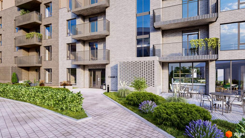 Зовнішній вигляд новобудови ЖК Статус Парк з цегляним фасадом та балконами. Прибудинкова територія з доглянутими кущами та лавандою.