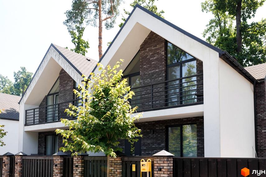 Будинки Житлового комплексу Respublika: темно-цегляні фасади, білі стіни, великі вікна, балкони. На передньому плані зелене дерево та паркан.