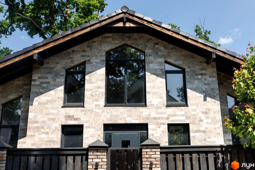 Котеджне містечко КМ Park Residence 3. Фасад будинку оздоблений натуральним каменем, великі вікна та дерев'яна огорожа.