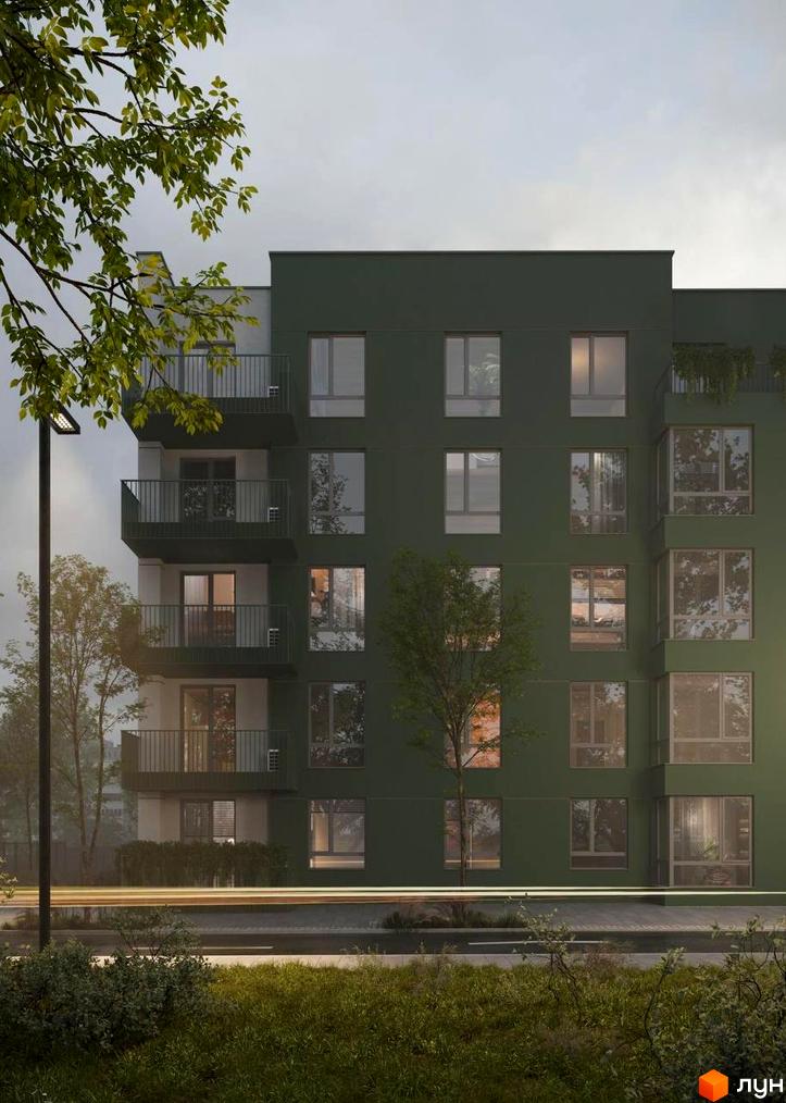 Зовнішній вигляд житлового комплексу Смарагд з зеленим фасадом та балконами. Навколо комплексу дерева та вуличне освітлення.