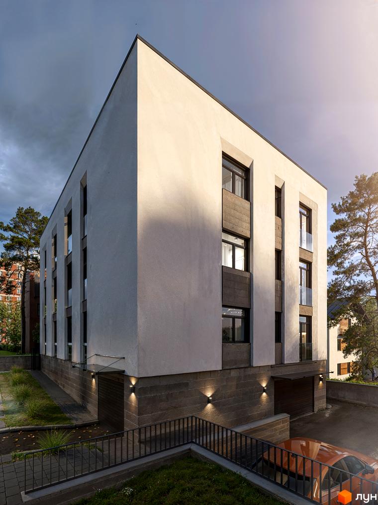 Житловий комплекс The9: фасади будинку з великими вікнами та балконами. Територія біля будинку з освітленням та парковкою.