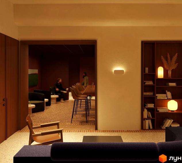 Інтер'єр апарт-готелю PRAUD select з диваном, кріслом, барною стійкою та полицями з декором. Затишна атмосфера для відпочинку та роботи.