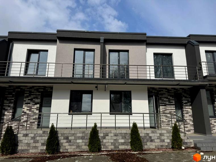 Зображення фасаду та балконів Котеджного містечка VIVA-CHERNIVTSI. Двоповерхові будинки з оздобленою прибудинковою територією та декоративними туями.