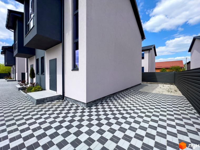Котеджне містечко Одеський: фасади будинків з сірим та білим оздобленням, вимощення з сіро-білої плитки.