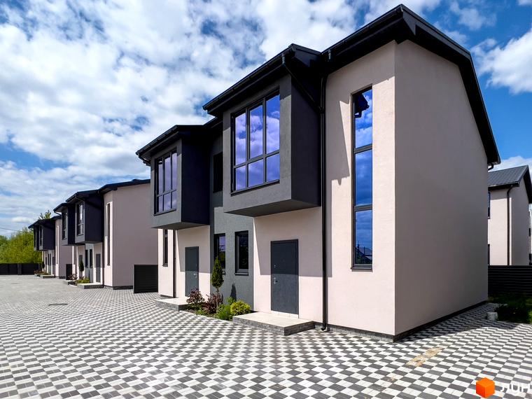 Котеджне містечко КМ Одеський. Сучасні двоповерхові будинки з великими вікнами та сірою оздобою фасаду, розташовані на бруківці з геометричним візерунком.