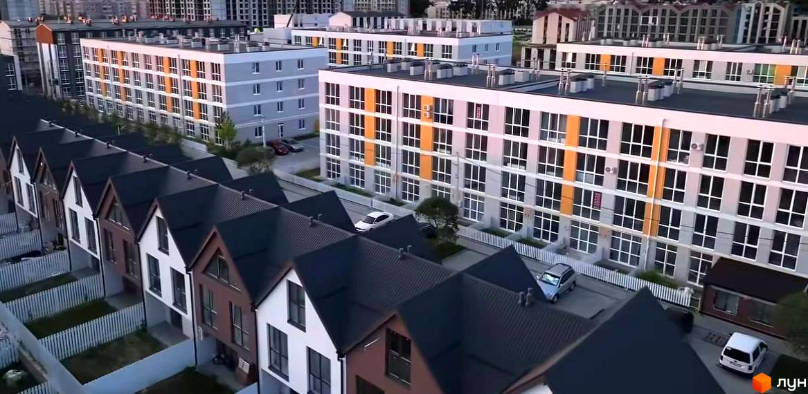 Житловий комплекс Sanville Park з будинками різної поверховості. На передньому плані котеджі з темними дахами, позаду багатоповерхові будинки з великими вікнами.