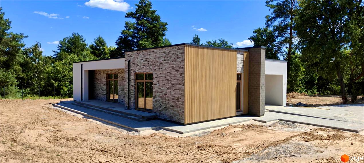 Котеджне містечко LOTUS: одноповерховий будинок з цегляним та дерев'яним фасадом, вікнами та прибудинковою територією з бруківки.