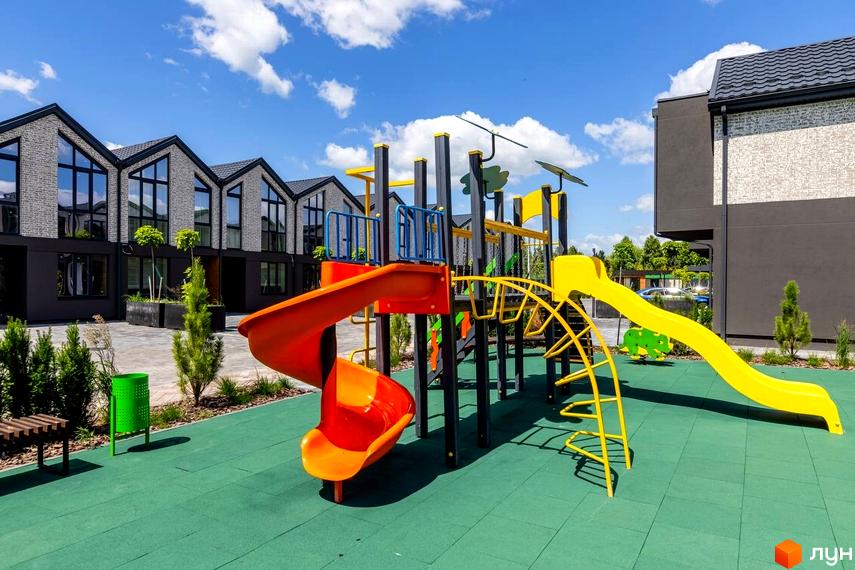 Котеджне містечко Romankiv Village з дитячим майданчиком та сучасними будинками. Територія комплексу доглянута, з зеленими насадженнями.