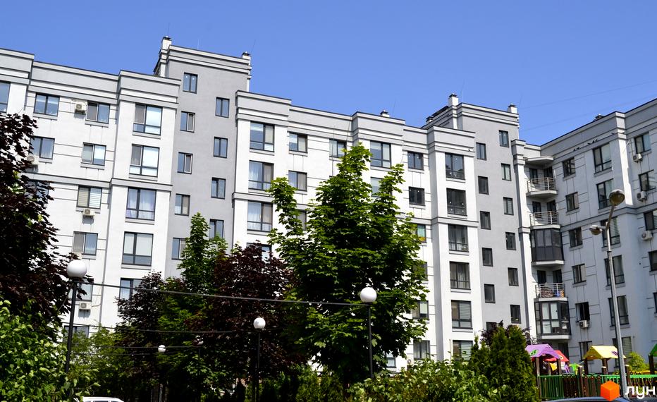 Житловий комплекс Новий Хотів - фасади будівель з великою кількістю вікон та балконів, дитячий майданчик на прибудинковій території.