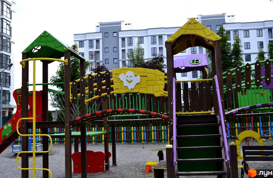 Дитячий майданчик біля новобудов ЖК Новий Хотів. На майданчику гірки, гойдалки та пісочниця.