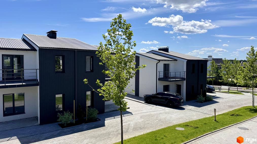 White-Blackie Duplex – це житловий комплекс з двоповерховими будинками чорно-білої гами, розташований на брукованій території з доглянутими газонами та деревами.