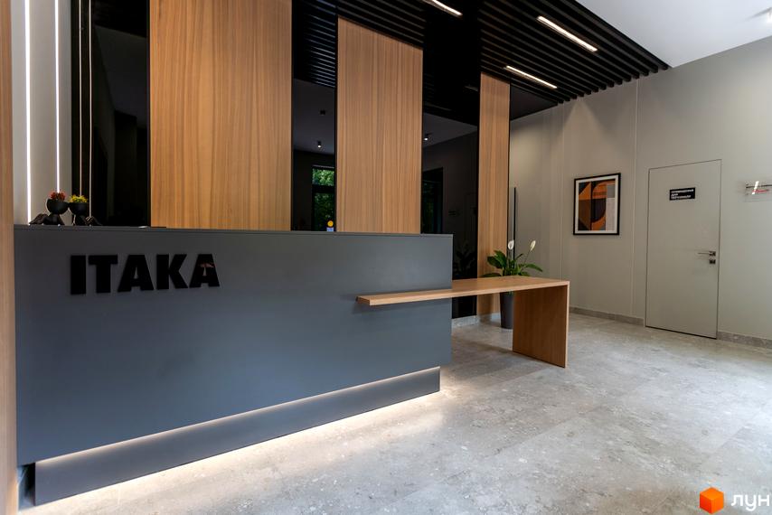 Апарт-комплекс Ітака: сучасний рецепшн з дерев'яними панелями та логотипом 