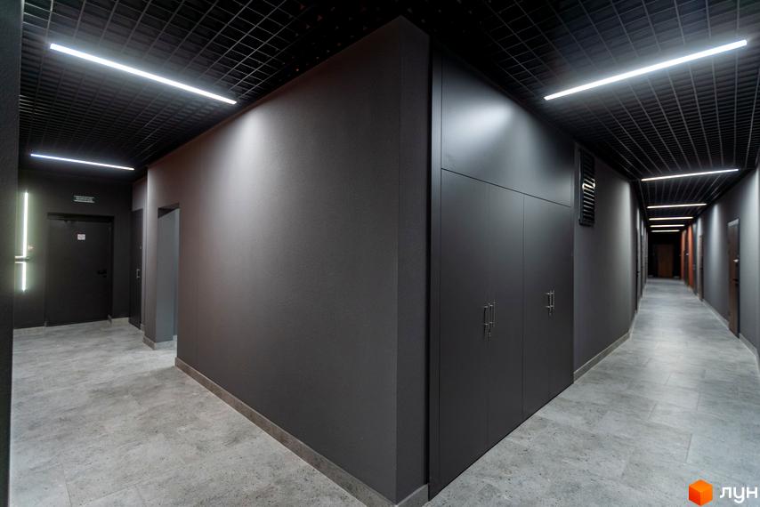 Апарт-комплекс Ітака. Сучасний коридор з сірою обробкою стін та підлоги, вбудованими шафами та дверима.