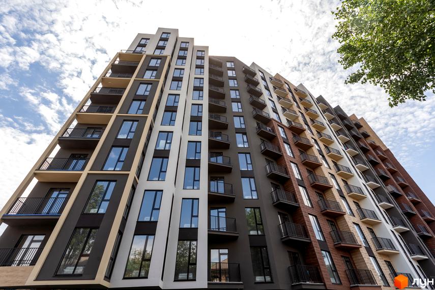 Апарт-комплекс Ітака - фасади будівель з балконами та великими вікнами під блакитним небом з хмарами.