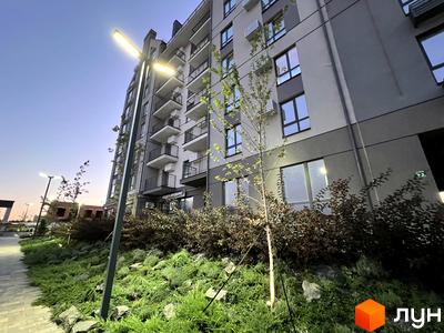 Житловий комплекс Park Residence з фасадом сірого та бежевого кольору, балконами та озелененою прибудинковою територією з деревами та кущами.