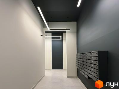 Вхідна група в новобудові ЖК Стандарт з індивідуальними поштовими скриньками та сучасним освітленням. Оздоблення стін та стелі виконано в нейтральних тонах.