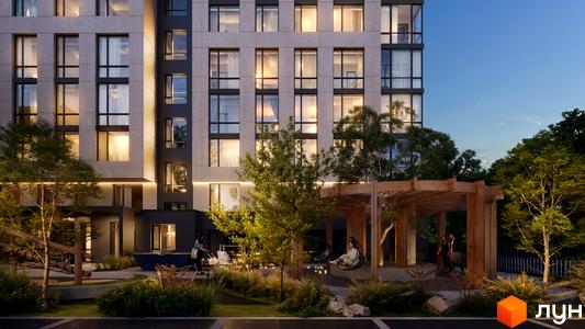 Новобудова D25 з великими вікнами та підсвіткою фасаду. На прибудинковій території розташовані зони відпочинку з навісом та зелені насадження.