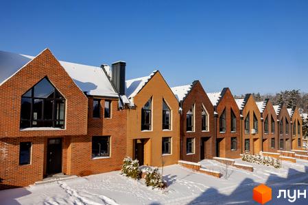 Житловий комплекс Таунхауси FORT HOMES з червоної цегли, з дахами у формі трикутників. Прибудинкова територія засипана снігом.