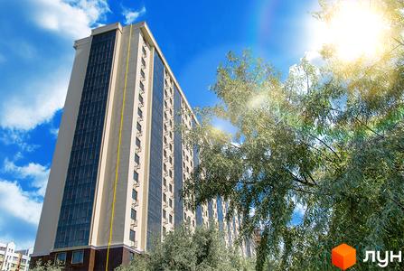 Житловий комплекс Двадцята Перлина: багатоповерховий будинок світлого кольору з темними вікнами та балконами, оточений зеленими деревами під сонячним небом.