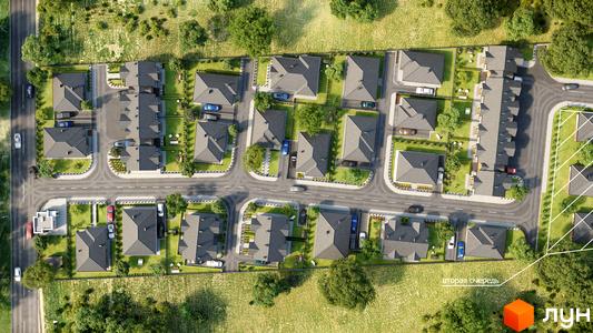 Котеджне містечко Щасливий Хуторок. Аерофотозйомка котеджів з сірими дахами та доглянутими зеленими ділянками, розташованих вздовж доріг.