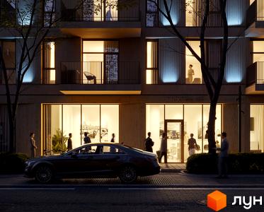 Житловий комплекс Avalon Yard Club з фасадом з натуральних матеріалів та підсвіткою, навколо зелена зона з деревами та комфортне освітлення вулиці.