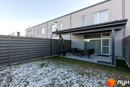 Котеджне містечко Balaton Village: сіра стіна двоповерхового будинку з терасою, вуличними меблями та газоном зі снігом. Огороджена територія з дерев'яним парканом.