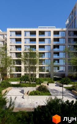 Житловий комплекс MECENAT з цегляним фасадом та скляними балконами, оточений зеленою прибудинковою територією з лавками.