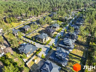 Котеджне містечко ZAHRAVA village 2: сучасні будинки з темними дахами серед соснового лісу. Прибудинкова територія з доглянутими газонами та деревами.