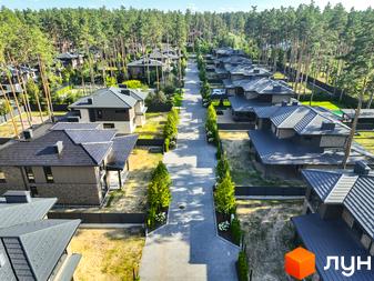 Котеджне містечко ZAHRAVA village 2: сучасні будинки з темними дахами та акуратними прибудинковими територіями, оточені соснами.