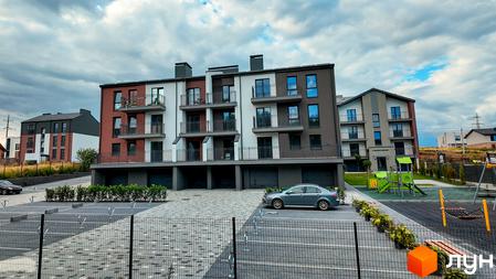 Житловий комплекс Вілла Швейцарія – це сучасна новобудова з цегляним фасадом та балконами, поруч розташований дитячий майданчик.