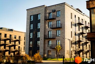 Зовнішній вигляд будинку в Житловому комплексі Долішній. Багатоповерхова будівля з балконами та великими вікнами.