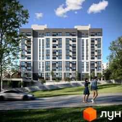 Житловий комплекс Смарагд - багатоповерхова новобудова з сірими та білими фасадами, великими вікнами та балконами. Навколо будинку зелена територія з деревами та дорогою.