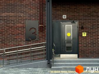 Вхідна група новобудови ЖК Стандарт з пандусом та сходами, облицьована цеглою. Зовнішній вигляд будівлі та прибудинкової території.