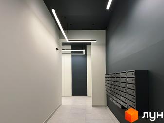 Вхідна група в новобудові ЖК Стандарт з індивідуальними поштовими скриньками та сучасним освітленням. Оздоблення стін та стелі виконано в нейтральних тонах.