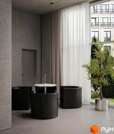 Багатоповерховий будинок Circle hotel&apartments з фасадом світлого кольору, великими вікнами та балконами з огорожами. Прилегла територія озеленена деревами та кущами.