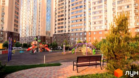 Житловий комплекс Перлинний квартал на Сахарова з сучасним фасадом та прибудинковою територією з дитячим майданчиком.