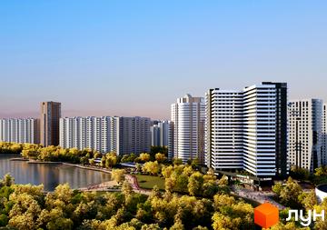 Житловий комплекс S1 Позняки з біло-чорними фасадами, розташований біля озера з парковою зоною та деревами.