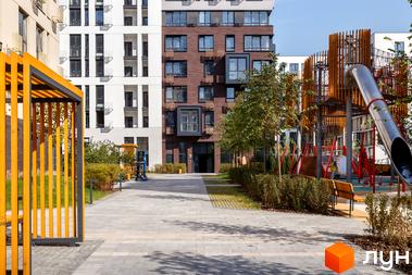 Зовнішній вигляд будинку в Житловому комплексі Файна Таун. На фото прибудинкова територія з ландшафтним дизайном та дитячим майданчиком.