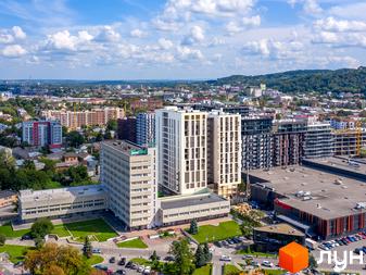 WELL towers – апарт-комплекс з білими фасадами та скляними балконами, розташований поруч із зеленим парком та торговим центром.