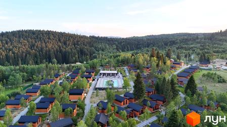 Котеджне містечко PHOENIX MEDICAL RESORT з дерев'яними будинками та чорними дахами, розташоване серед лісу біля басейну та зони відпочинку.