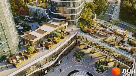 Зовнішній вигляд житлового комплексу The Light з вигнутими скляними фасадами та терасами з зонами відпочинку. Навколо комплексу зелена територія з деревами та квітами, а також дорога з автомобілями.